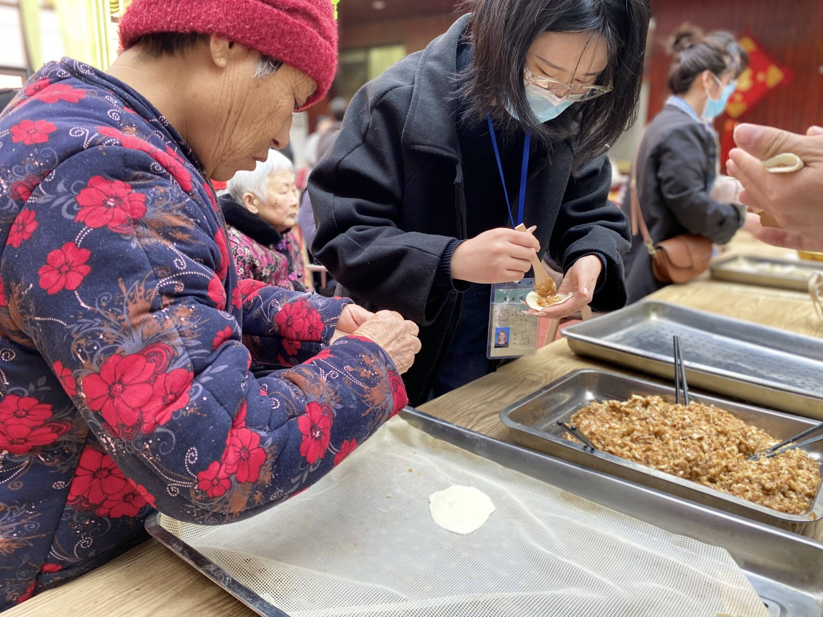 志愿者与老人们共同包饺子.JPG